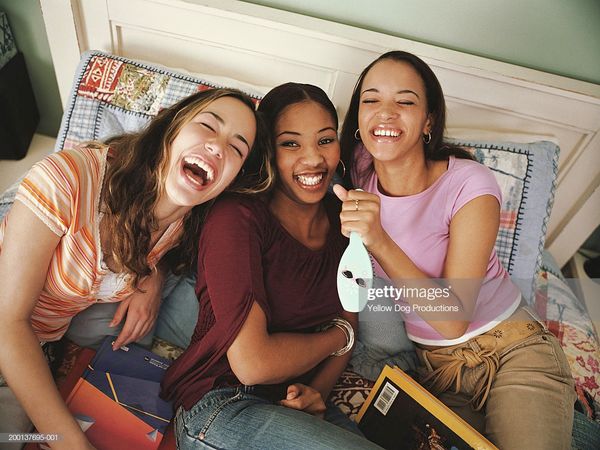 Three Teenage Girls On Bed Laughing