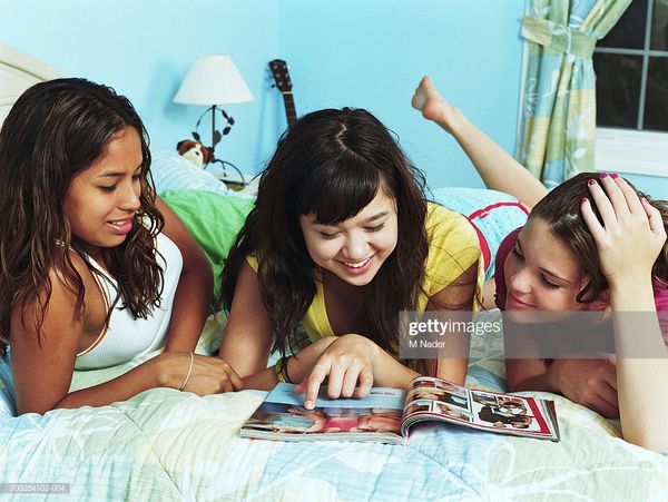 Three Teenage Girls On Bed Looking