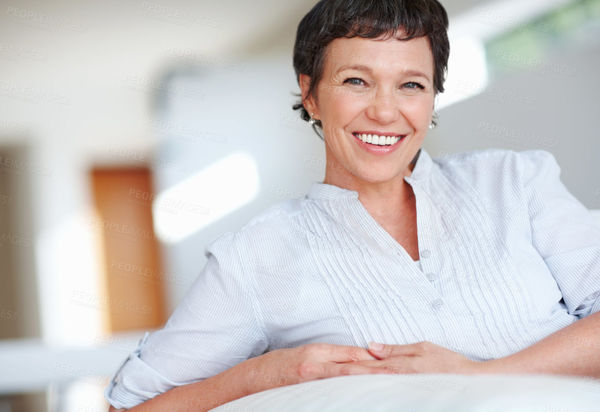 Smiling mature woman on couch Buy Stock Photo on PeopleImage