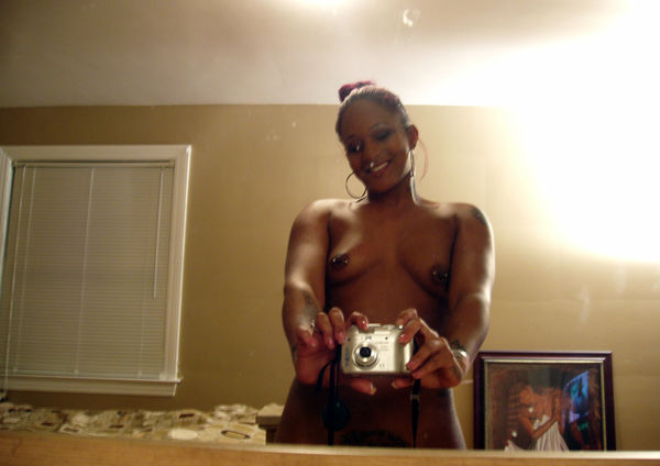 Tattoed young ebony taking pictures