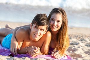 Teen couple together on beach. - Stock