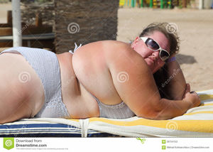Overweight woman on beach stock