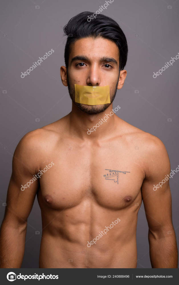 Young handsome Persian man shirtless against gray background