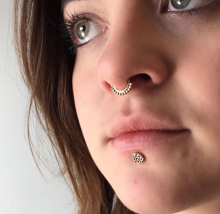 Septum piercing with a rose gold latchmi ring and a labret p